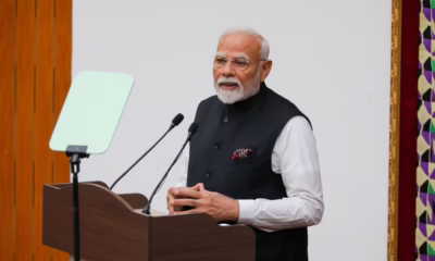 Man speaking at podium with teleprompter