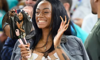 Woman smiling and waving at outdoor event