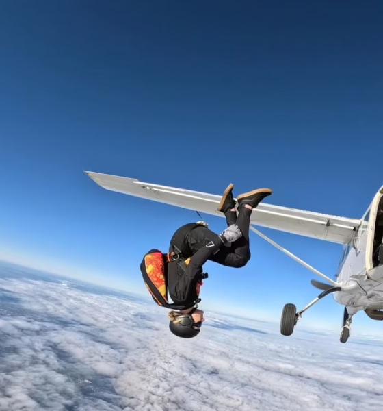 Skydiver jumping from airplane over clouds