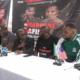 Boxing press conference with speakers and microphones.